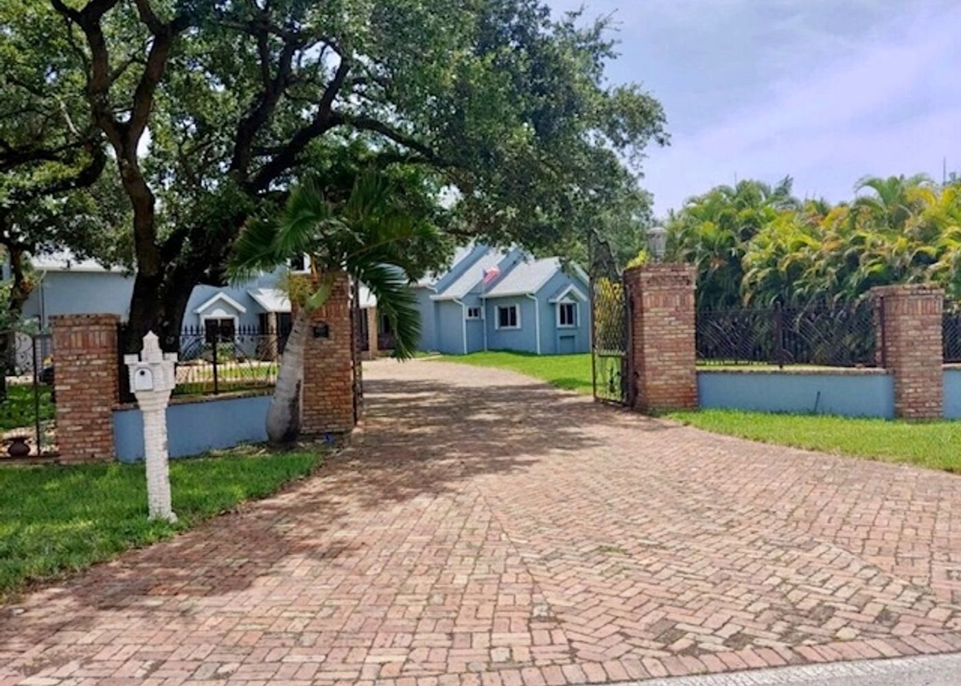 Old Chicago Brick driveway with brick columns and an ornamental gate, an All Around Turf & Pavers project in Miami